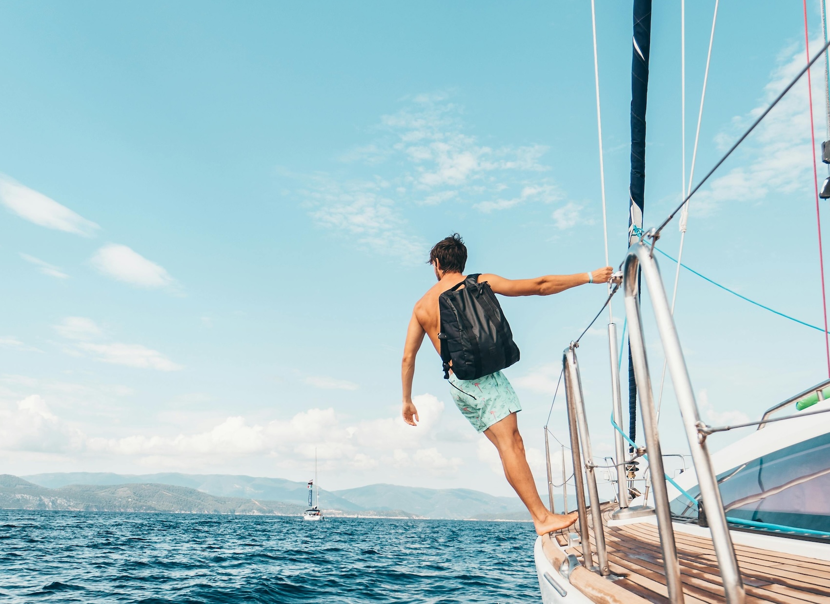 Boy hanging on sailboat